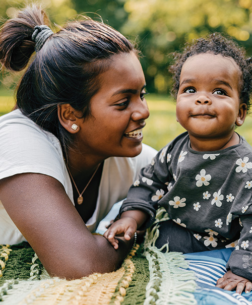 A mother smiling warmly at her baby.